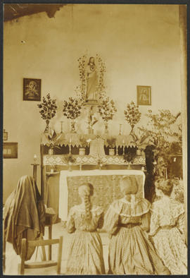 Crianças rezando frente a imagem sacra