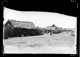 Moradores em frente a casas de pau-a-pique