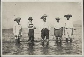 Cinco homens trajando roupas e chapéu de palha
