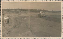 Vista do terreno para construção do Sanatório de Curicica, com tratores e Angelo Cruz e outro a e...
