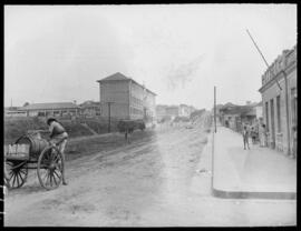 Homem carregando barril em carroça. Rua na área central - Jacarezinho (PR)