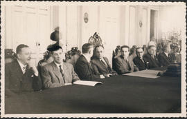 Clemente Mariani e outros sentados a mesa durante visita à Santa Casa de Misericórdia