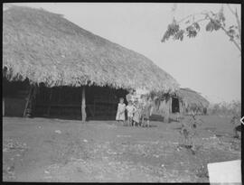 Família   em frente à casa de José Rodrigues, na Fazenda São Francisco. Vista do roçado de mandio...
